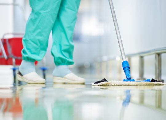 worker cleaning floor with mop